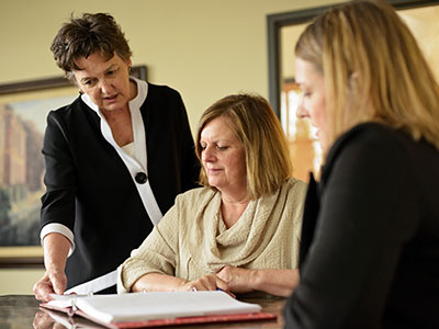 two elder law attorneys reviewing planning documents with client
